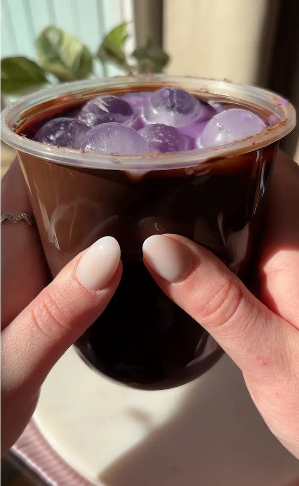 Recette gourmande : coques de chocolat noir fourrées à la poudre d'ube violet, fondantes et crémeuses dans un cold brew
