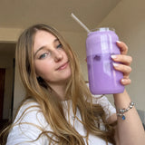 La co-fondatrice d'Ube-Ube tenant un ube latte glacé à la poudre d'ube dans un grand verre avec paille en verre