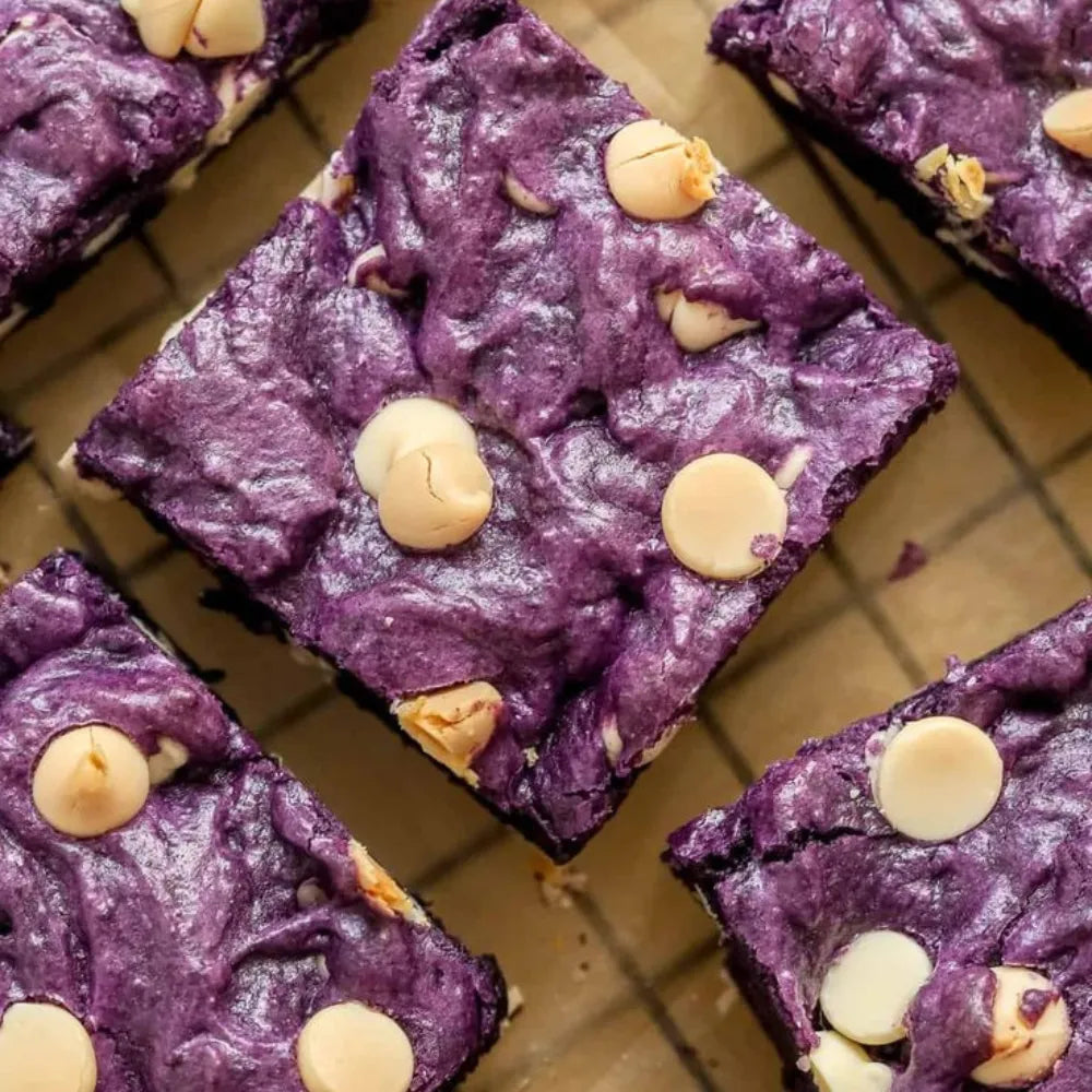 Brownies à la poudre d'ube violet intense et chips de chocolat blanc, texture fudgy et gourmande sur grille de refroidissement